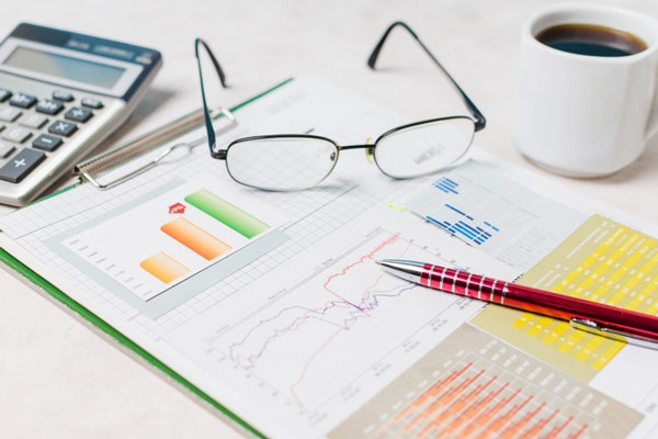 A calculator and pen on a clipboard, representing the concept of business finance and accounting.