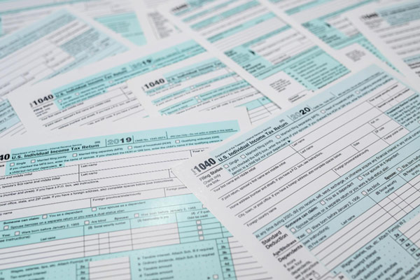 IRS handout photo shows tax forms on table.