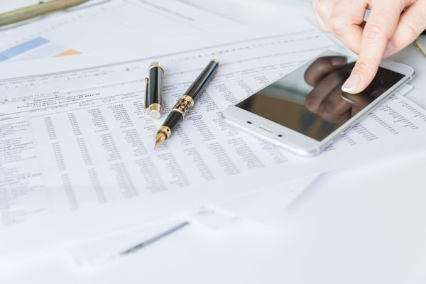 Reviewing financial documents on her smartphone.